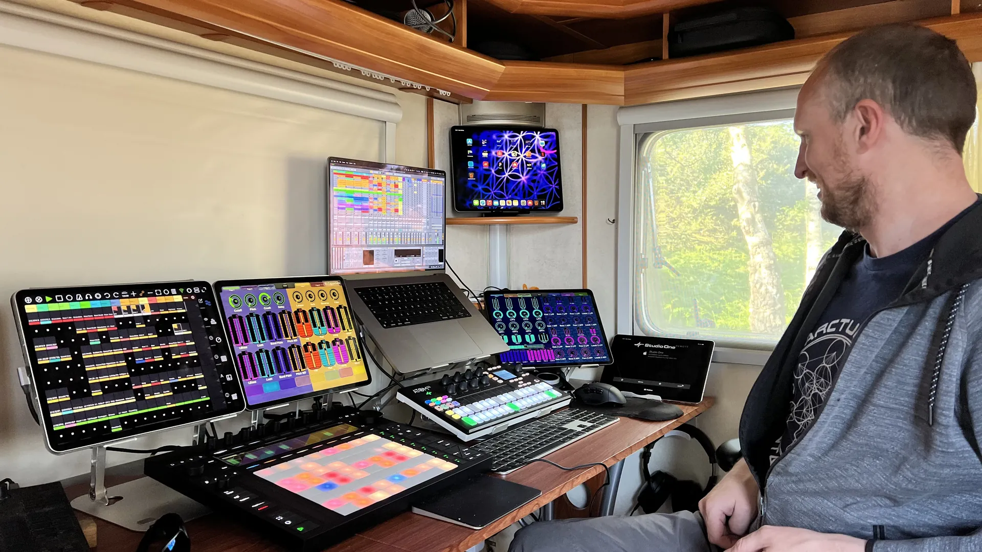 Adam Arcturus smiling beside his studio set-up